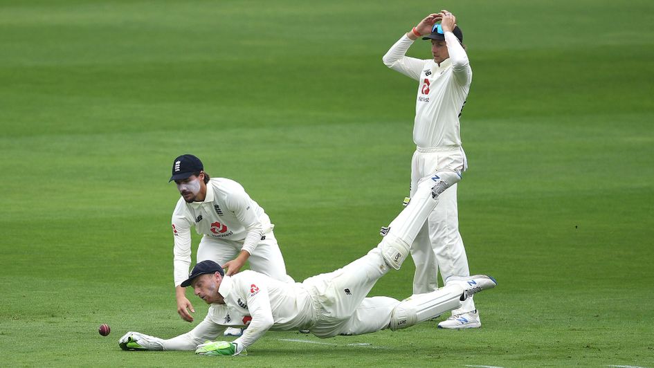England wicketkeeper Jos Buttler dives to catch a drop from Rory Burns