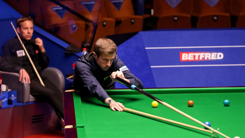 Jack Lisowski plays a shot with Ali Carter watching on